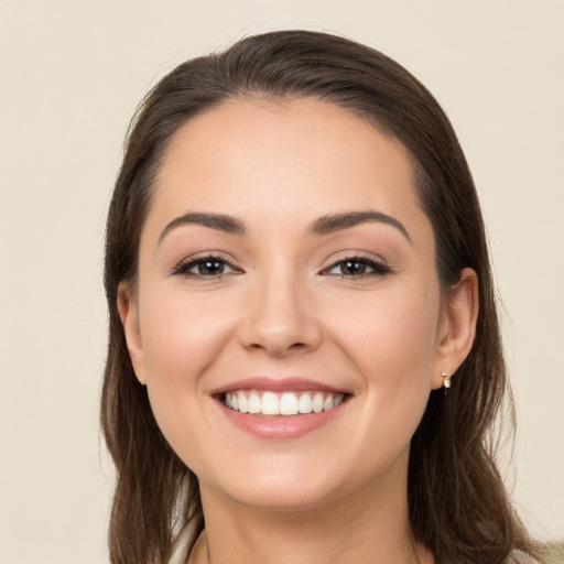 Joyful white young-adult female with long  brown hair and brown eyes