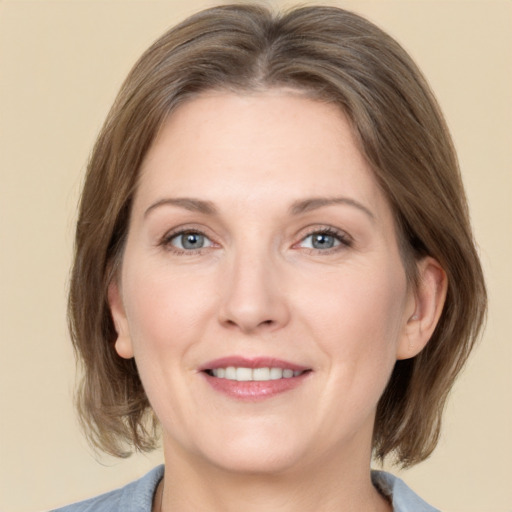 Joyful white adult female with medium  brown hair and grey eyes