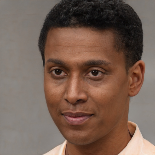 Joyful latino young-adult male with short  brown hair and brown eyes