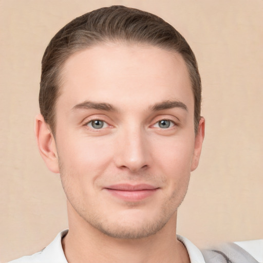 Joyful white young-adult male with short  brown hair and grey eyes