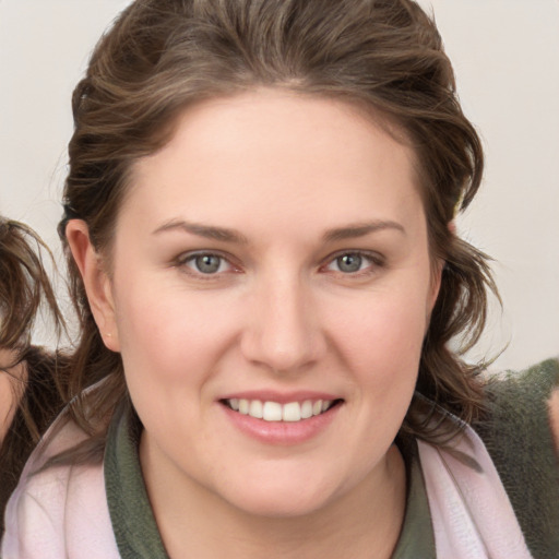 Joyful white young-adult female with medium  brown hair and blue eyes