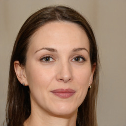 Joyful white adult female with long  brown hair and brown eyes