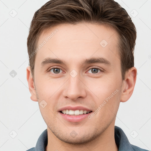 Joyful white young-adult male with short  brown hair and grey eyes