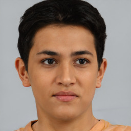 Joyful latino young-adult male with short  brown hair and brown eyes