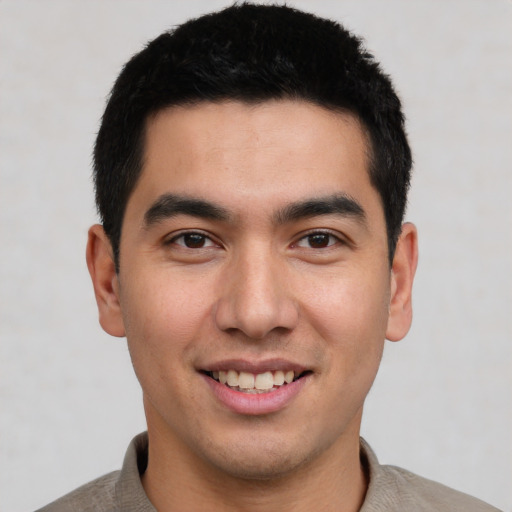 Joyful latino young-adult male with short  black hair and brown eyes