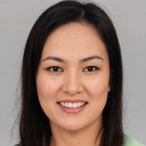 Joyful latino young-adult female with long  brown hair and brown eyes