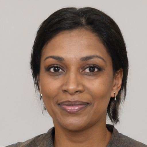 Joyful black adult female with medium  black hair and brown eyes