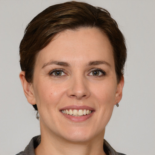 Joyful white young-adult female with medium  brown hair and grey eyes