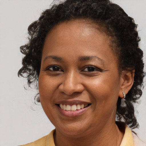 Joyful black young-adult female with medium  brown hair and brown eyes