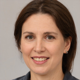 Joyful white adult female with medium  brown hair and grey eyes