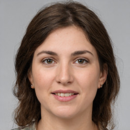 Joyful white young-adult female with medium  brown hair and grey eyes