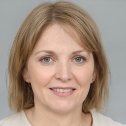 Joyful white adult female with medium  brown hair and blue eyes