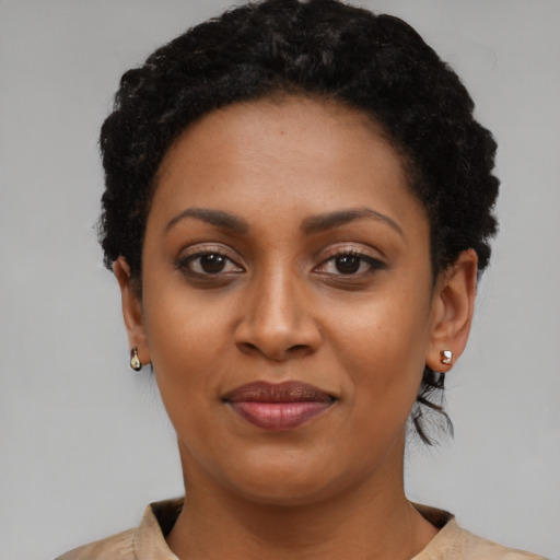 Joyful black young-adult female with short  black hair and brown eyes