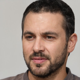 Joyful white adult male with short  black hair and brown eyes