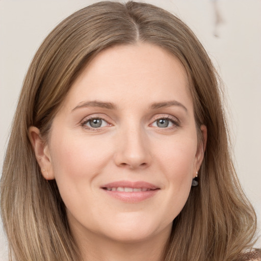 Joyful white young-adult female with long  brown hair and grey eyes