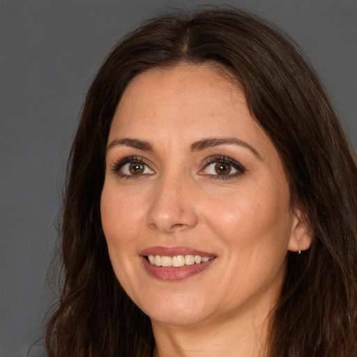 Joyful white adult female with long  brown hair and brown eyes