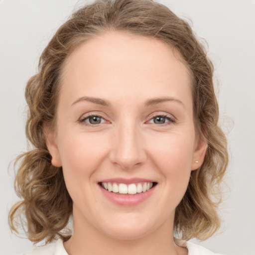 Joyful white young-adult female with medium  brown hair and blue eyes