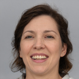 Joyful white adult female with medium  brown hair and grey eyes