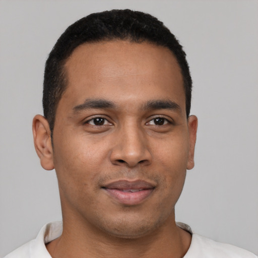 Joyful latino young-adult male with short  black hair and brown eyes