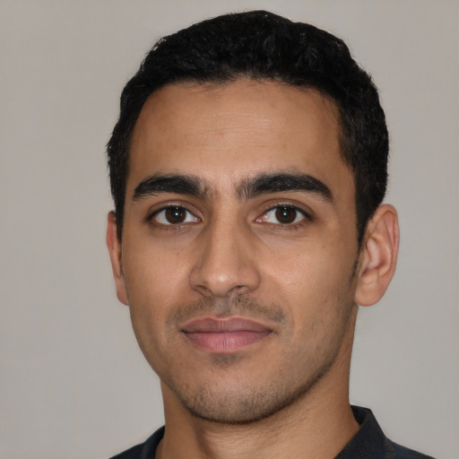 Joyful latino young-adult male with short  black hair and brown eyes