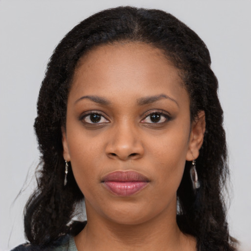 Joyful black young-adult female with long  black hair and brown eyes