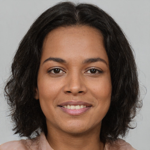 Joyful latino young-adult female with medium  brown hair and brown eyes