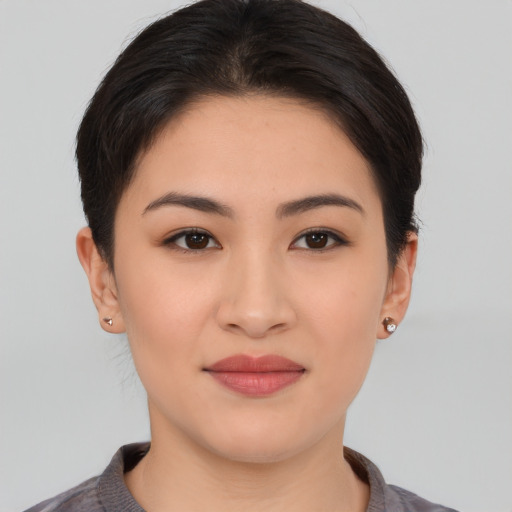 Joyful asian young-adult female with short  brown hair and brown eyes
