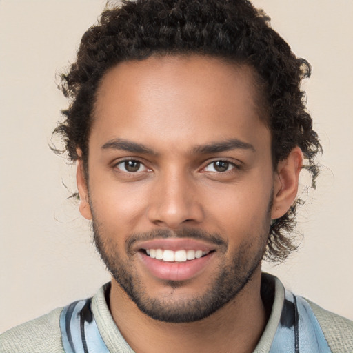 Joyful black young-adult male with short  brown hair and brown eyes