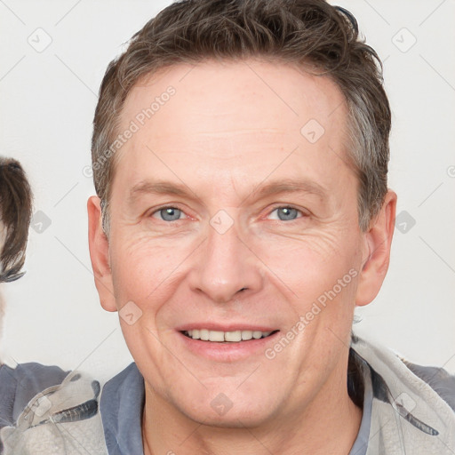 Joyful white adult male with short  brown hair and grey eyes