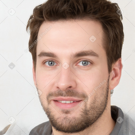 Joyful white young-adult male with short  brown hair and grey eyes