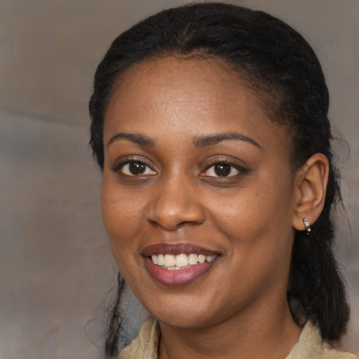 Joyful black adult female with long  black hair and brown eyes