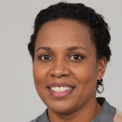 Joyful black adult female with short  black hair and brown eyes