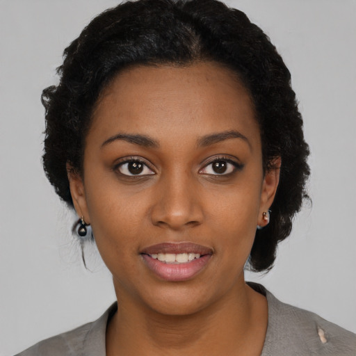Joyful black young-adult female with short  black hair and brown eyes