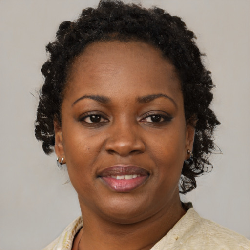 Joyful black adult female with short  black hair and brown eyes