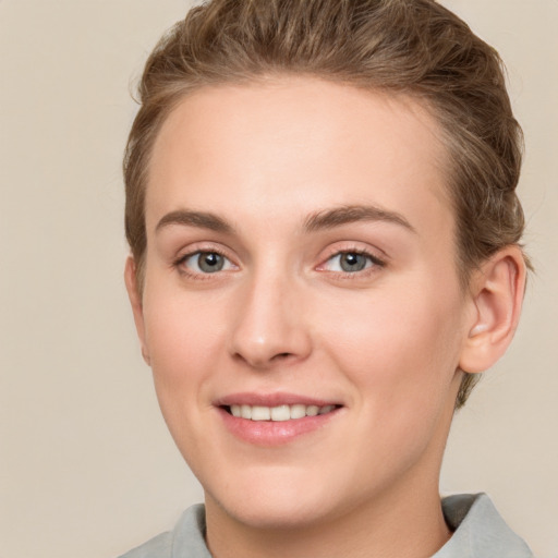 Joyful white young-adult female with short  brown hair and grey eyes