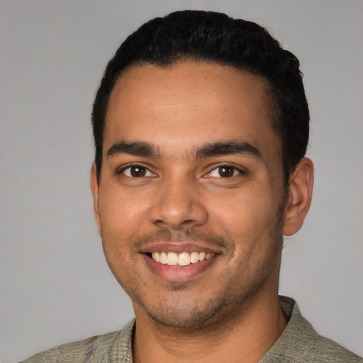 Joyful latino young-adult male with short  black hair and brown eyes