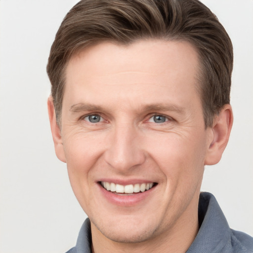 Joyful white adult male with short  brown hair and grey eyes