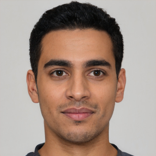 Joyful latino young-adult male with short  black hair and brown eyes