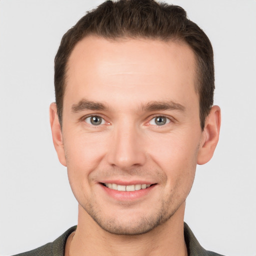 Joyful white young-adult male with short  brown hair and grey eyes