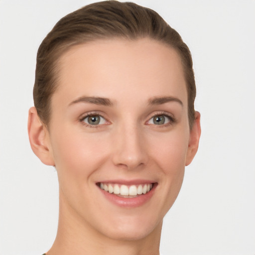 Joyful white young-adult female with short  brown hair and grey eyes