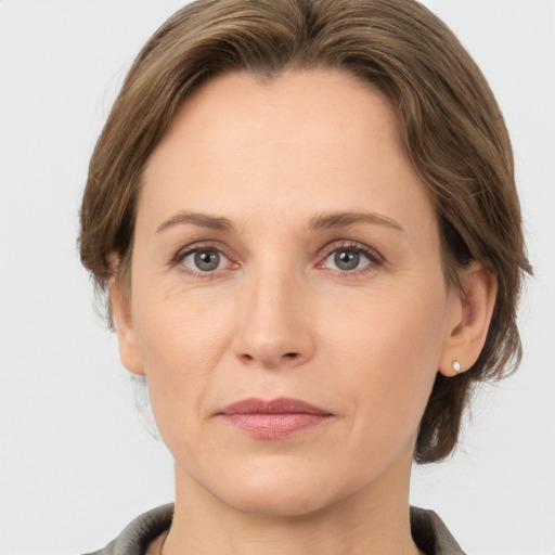 Joyful white adult female with medium  brown hair and grey eyes