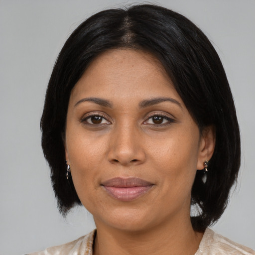 Joyful latino adult female with medium  black hair and brown eyes