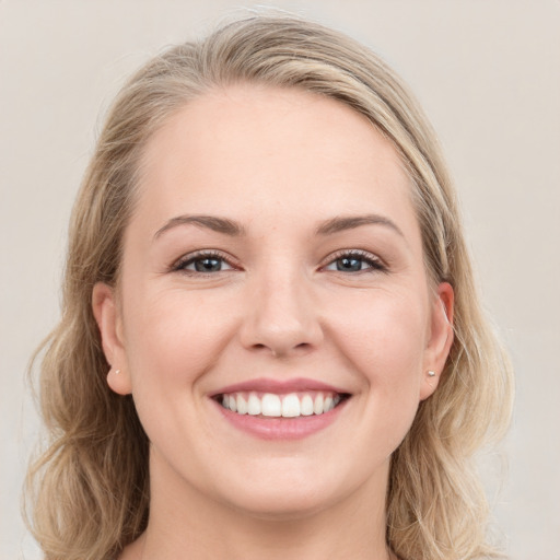 Joyful white young-adult female with long  brown hair and blue eyes