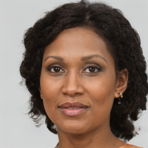 Joyful black adult female with medium  brown hair and brown eyes
