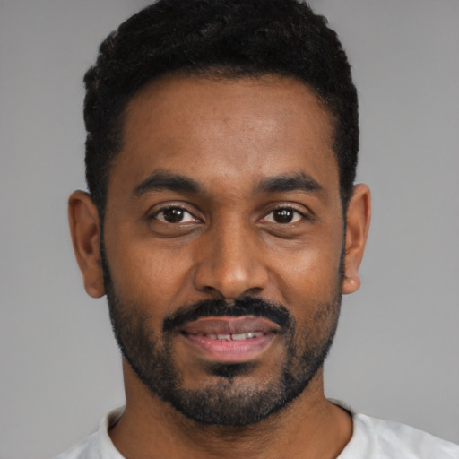 Joyful black young-adult male with short  black hair and brown eyes