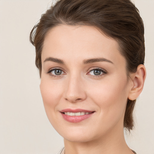 Joyful white young-adult female with medium  brown hair and grey eyes