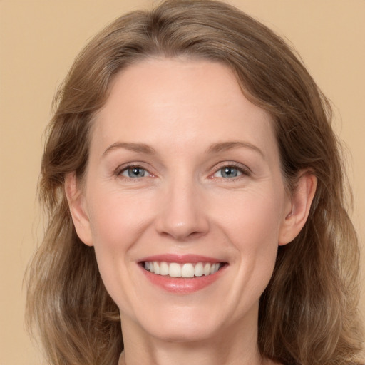 Joyful white adult female with medium  brown hair and grey eyes