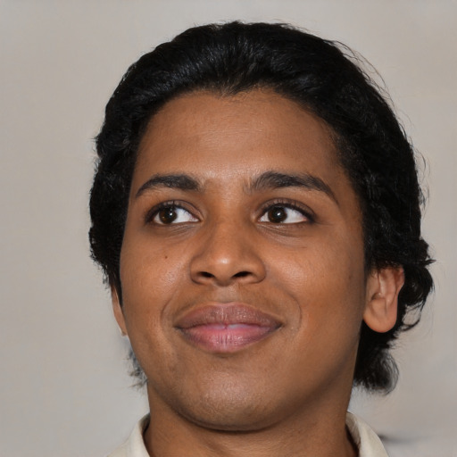 Joyful black young-adult male with medium  black hair and brown eyes