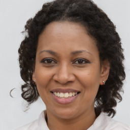 Joyful black adult female with medium  brown hair and brown eyes