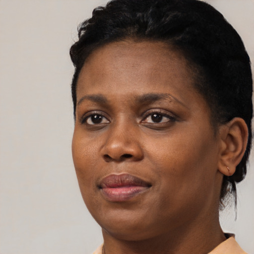 Joyful black young-adult female with short  black hair and brown eyes
